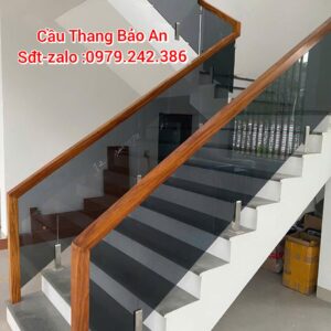CẦU THANG KÍNH ĐẸP XÁM KHÓI . LAN CAN CẦU THANG KÍNH TAY VỊN GỖ